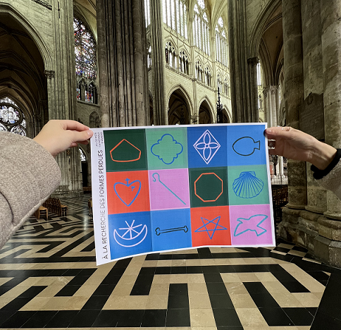 Quelqu'un tient une affiche avec des logos pour la cathédrale d'Amiens'